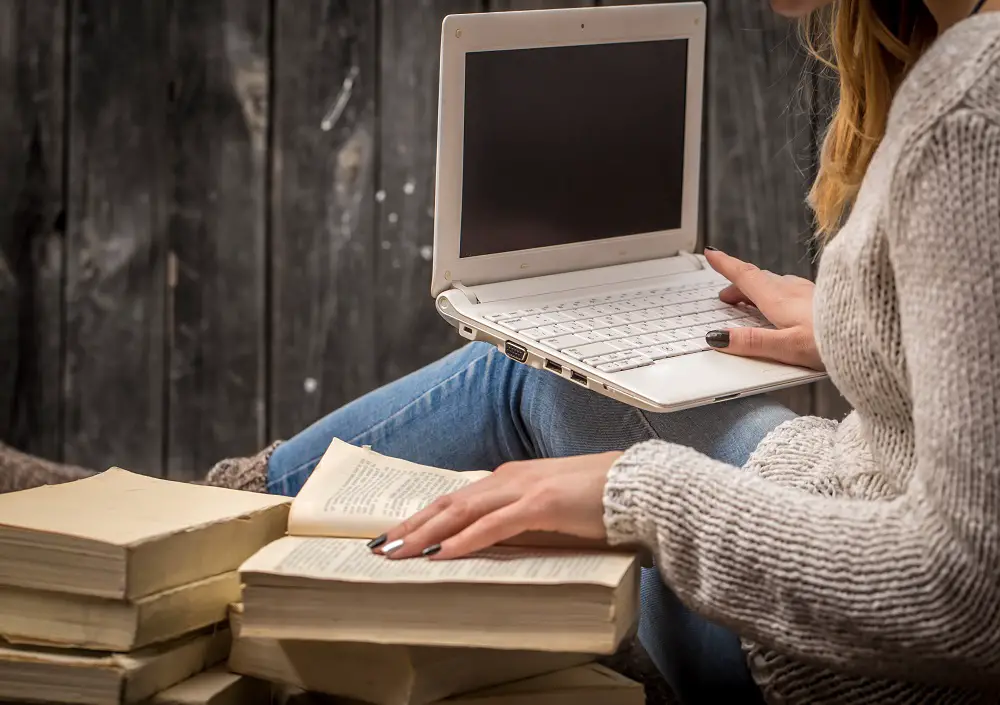 girl-sitting-floor-surrounded-by-many-white-books-large-candle